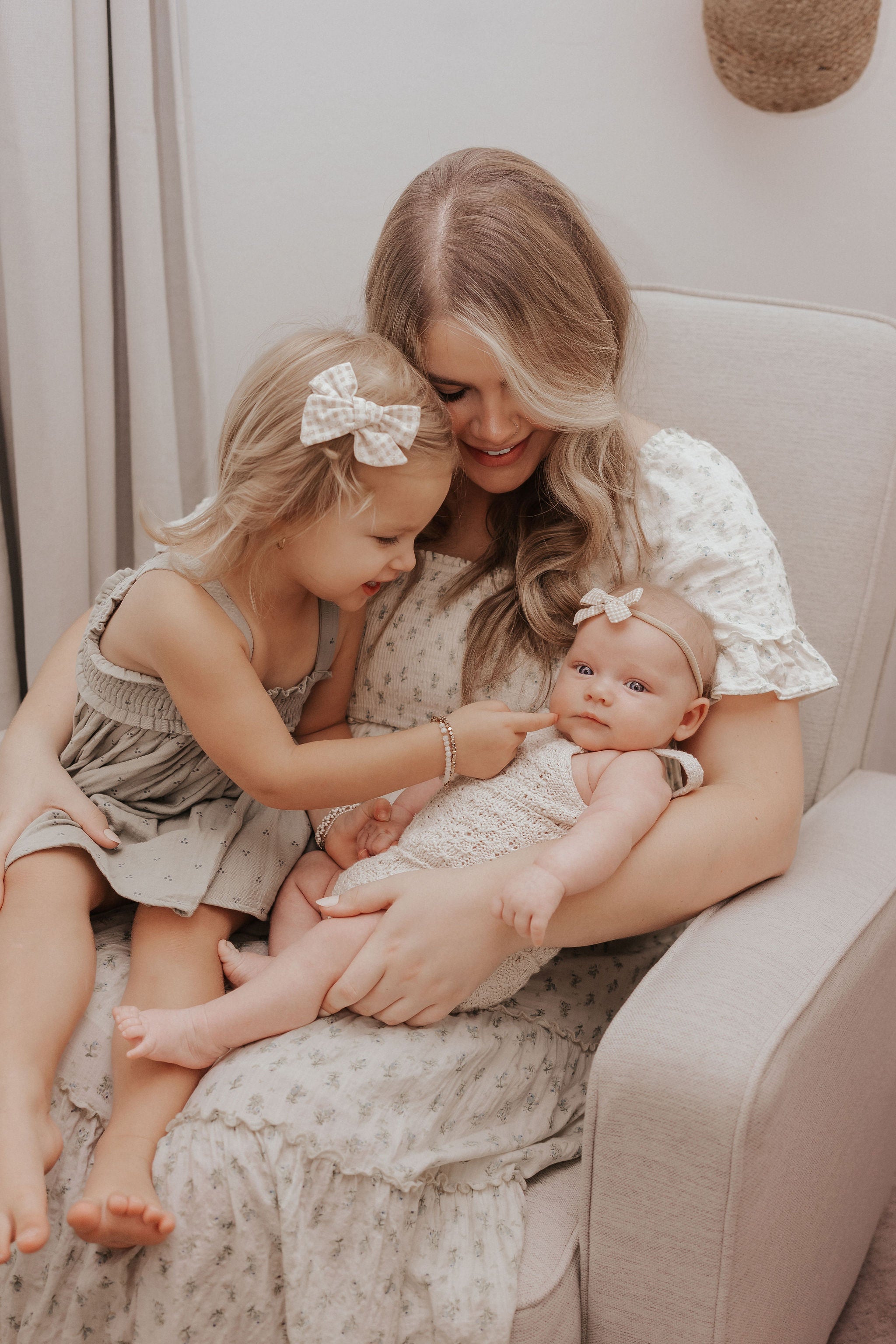 Kait Fosso, a mom, and owner of bowy lou, holding her 2 girls.