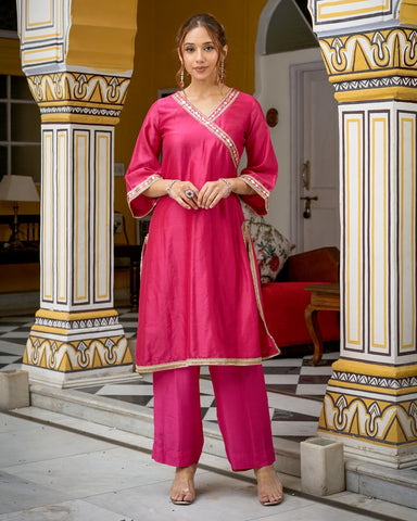 Graceful pink kurta set adorned with intricate Tamba work detailing for a stylish appearance