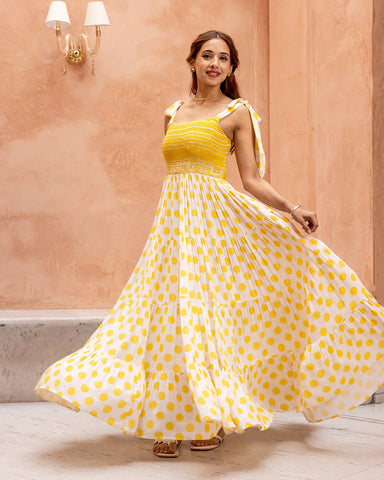 Sunny yellow dress featuring a smocked waist and charming polka dot print