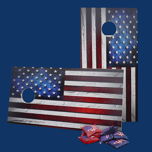 Cornhole game boards with an American flag design and bean bags nearby.
