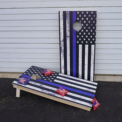 Cornhole game boards painted with an American flag theme, with bean bags on one board.
