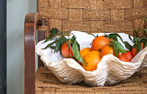 White clam shell bowl with fruits.