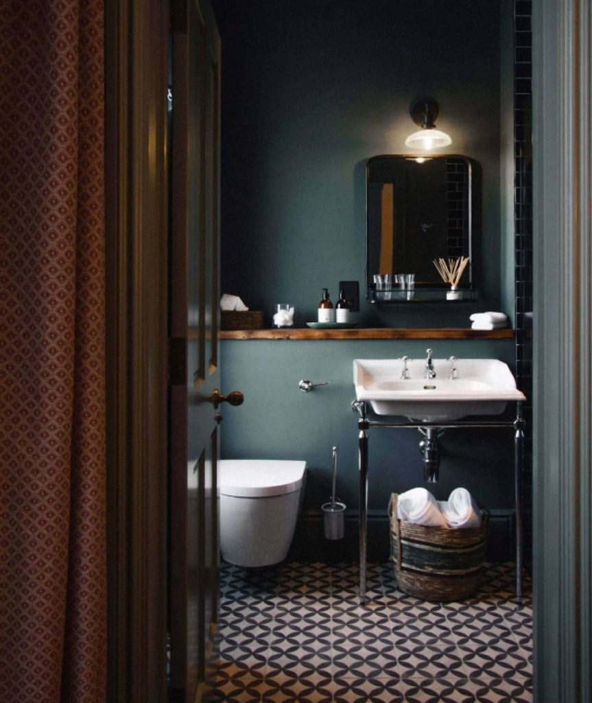 bathroom scene with dark green walls and monochrome tiles 