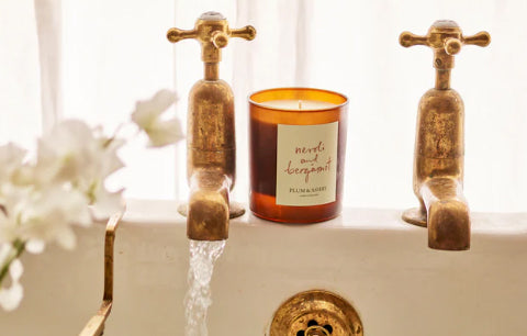 Neroli and bergamot candle on bathtub.