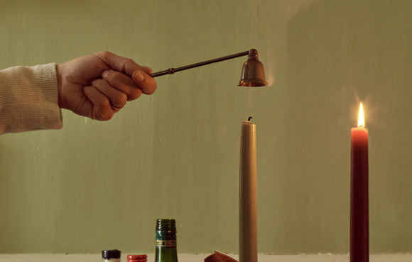Brass candle snuffer being used
