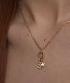 Woman wearing a gold Star Charm necklace adorned with diamonds, showcasing a delicate and elegant fashion accessory.