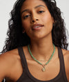 Green Aventurine Necklace With Vermeil Enhancer on a woman with curly hair, showcasing the handcrafted 18k gold vermeil and green aventurine gemstones.