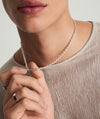 Person wearing a Trace Rectangle Chain Necklace, a modern and minimal handcrafted sterling silver accessory, with close-up on lips and fingers.