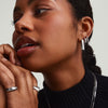 Woman wearing Chunky Large U Hoops with clicker closure, hands near face, showcasing comfort and security of the pillowy hoop earrings.