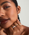 Close-up of a woman wearing Mini Baguette Diamond Studs, showcasing the 14k solid gold earrings with responsibly sourced diamonds.