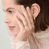 Close-up of a woman’s face with a 4mm Curve Band gold ring on her finger, highlighting the ring's elegance and lightweight design.