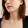 Woman wearing round diamond studs and a matching necklace, showcasing the elegance of the jewelry set.