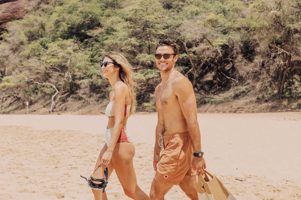 Two people walking out to snorkel at the beach