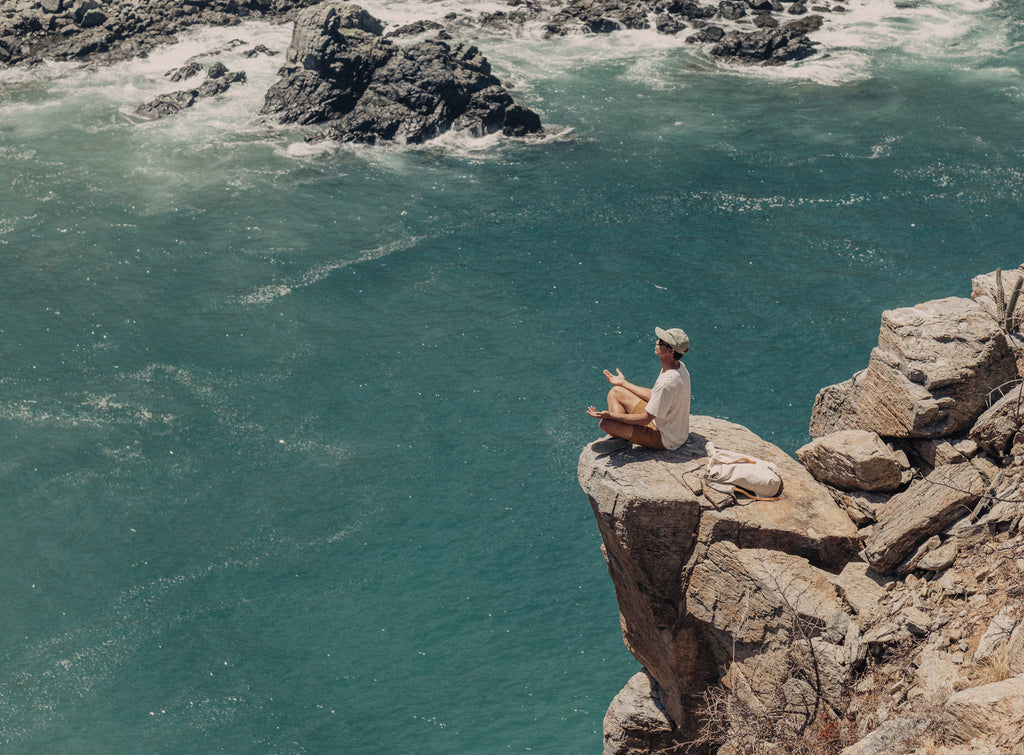 man meditating over the ocean