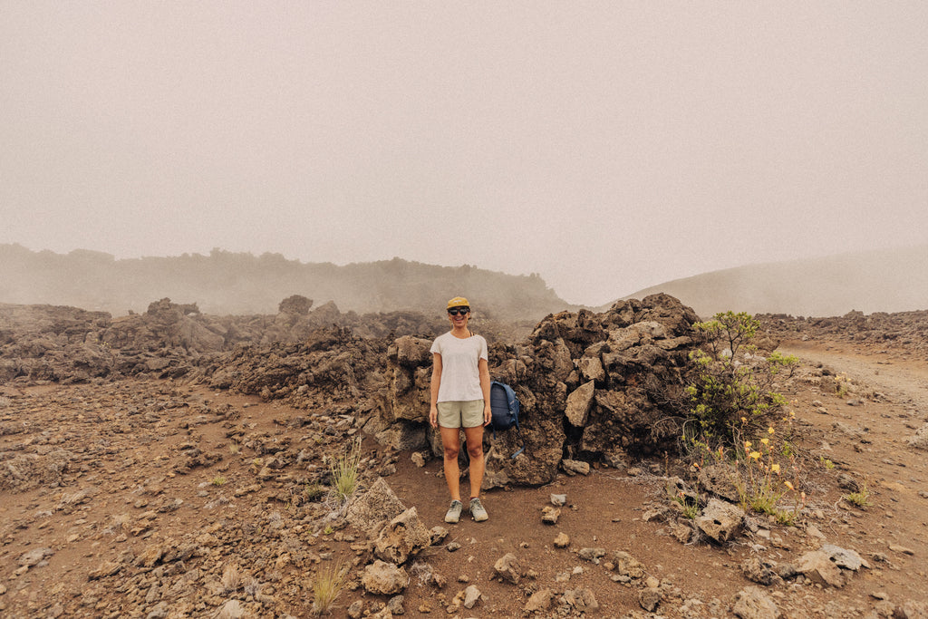 Woman standing by the rocks on a foggy hike, all smiles