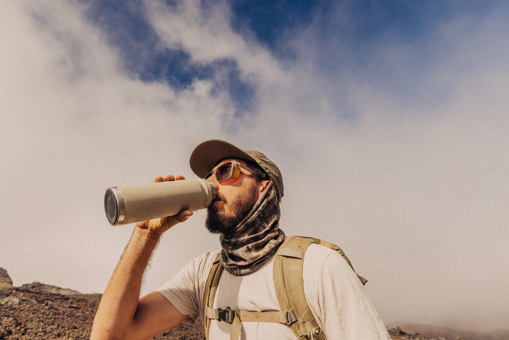 Sipping water out of a metal water bottle on a desert mountain hike