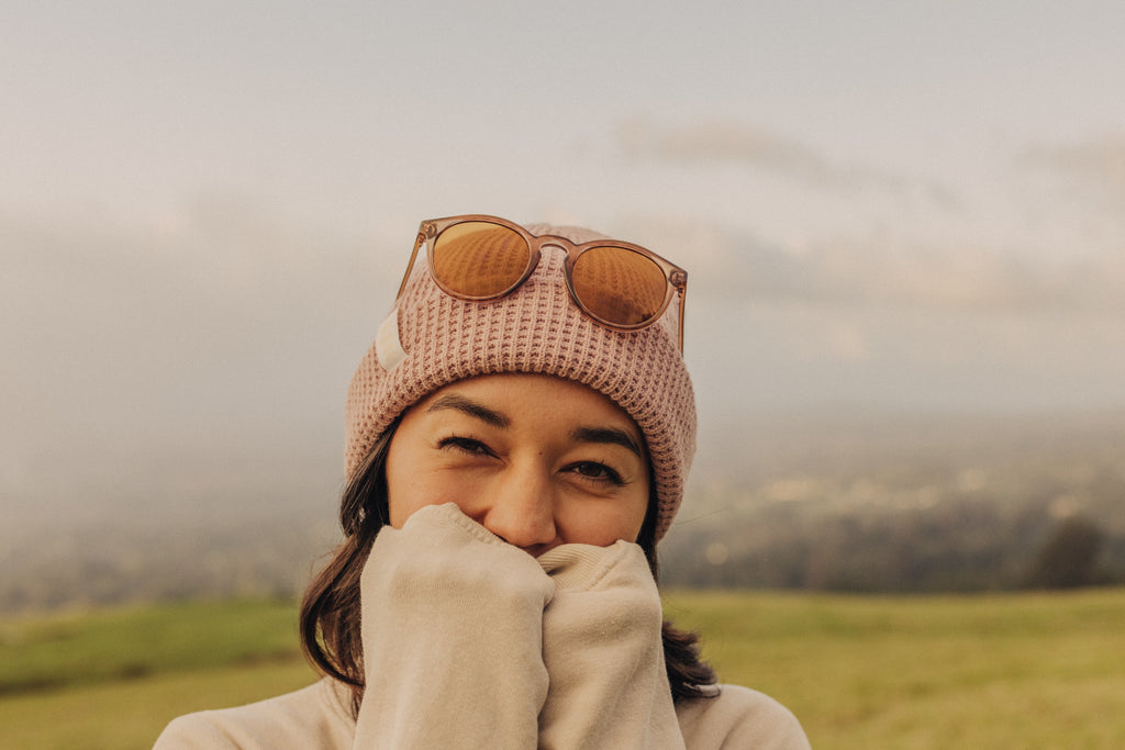 Woman cozy in sweater, beanie, and sunglasses