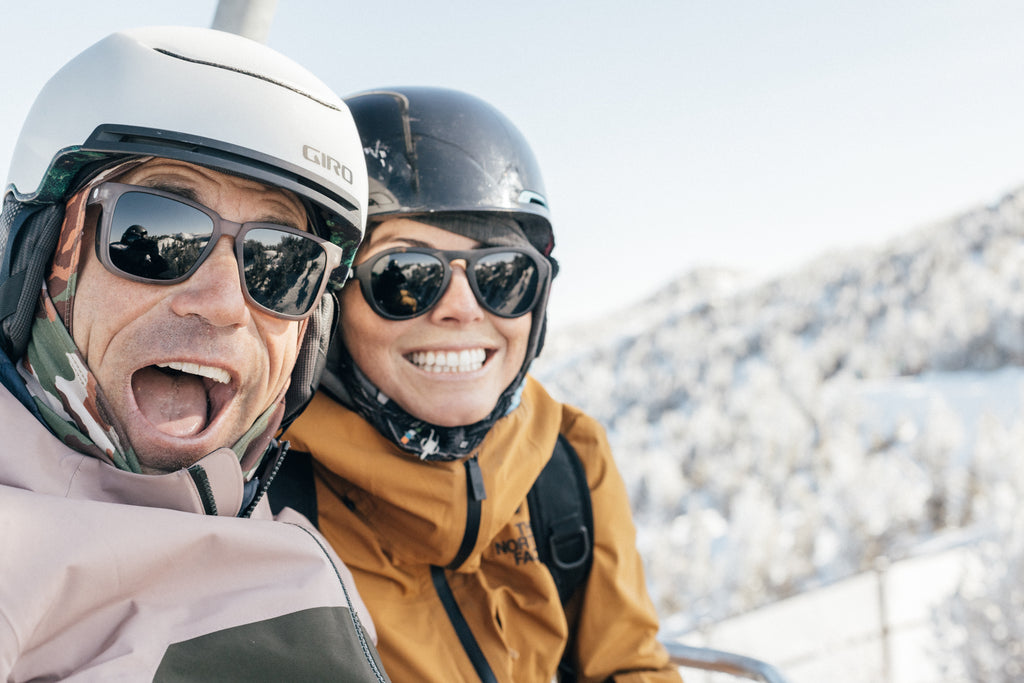 Man and woman all smiles on a ski lift