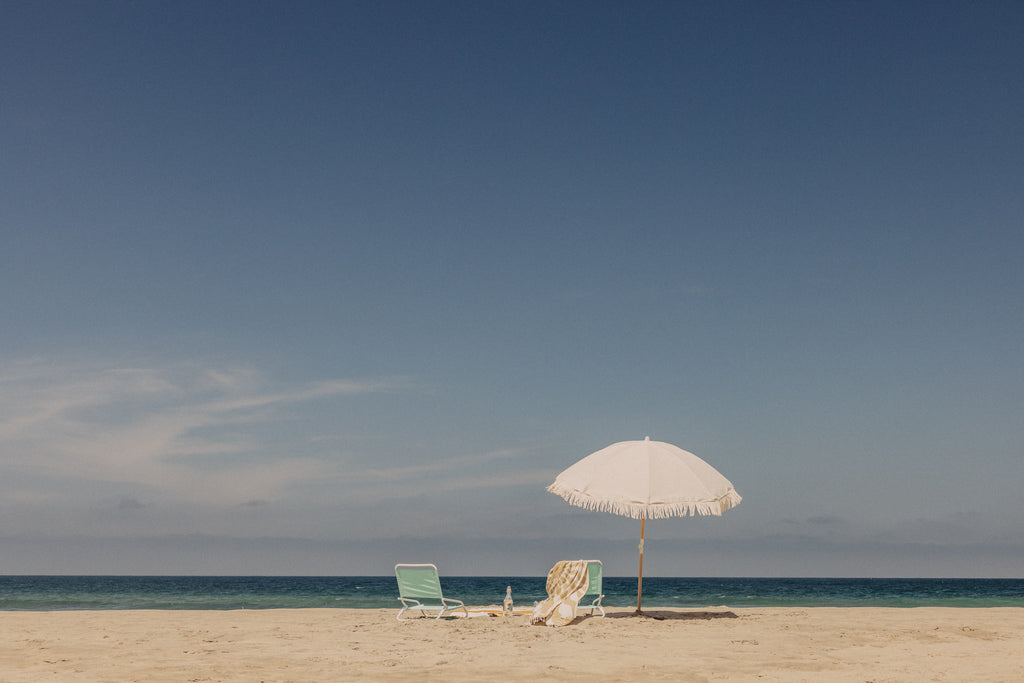 Umbrella and two chairs set up on a sandy beach
