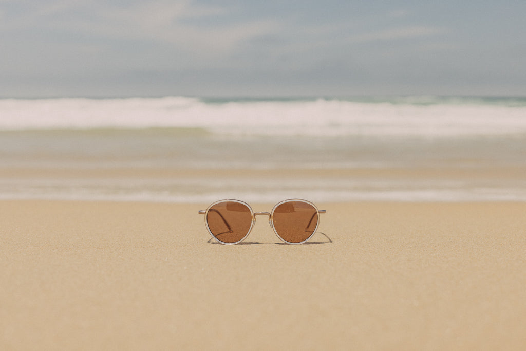 Sunski Baia sunglasses in the sand on beach