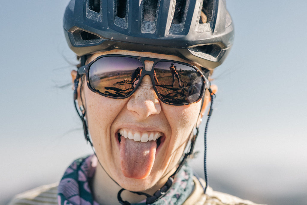 Woman sticking her tongue out while wearing pair of trending sunglasses