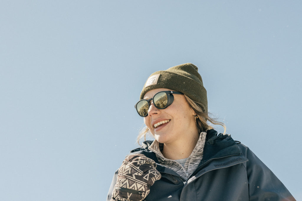 Woman in winter gear wearing alpine sunglasses