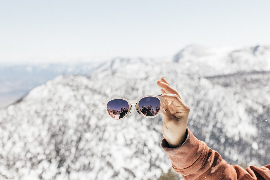 Alpine sunglasses against a snowy mountainous view