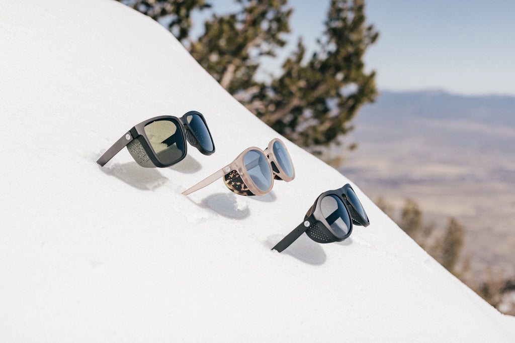 Three side shield sunglasses sticking out of the snow