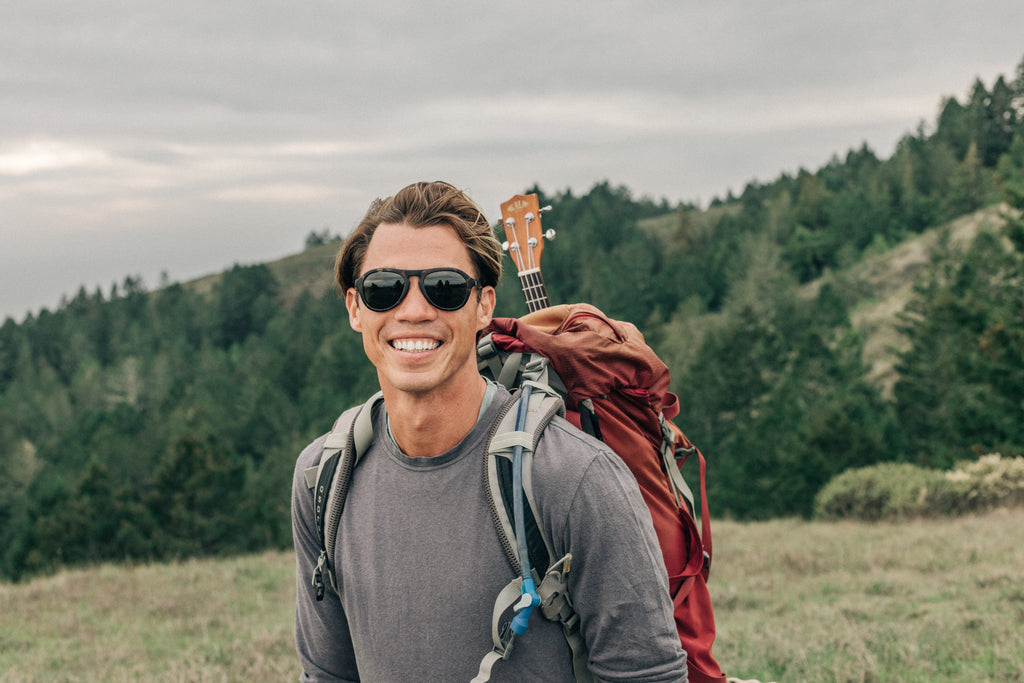 Guy all smiles with his ukelele on his hike
