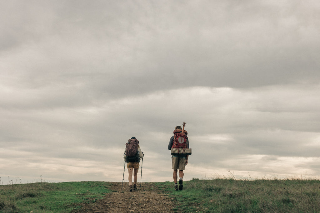 Backpacking through an open field on a cloudy day