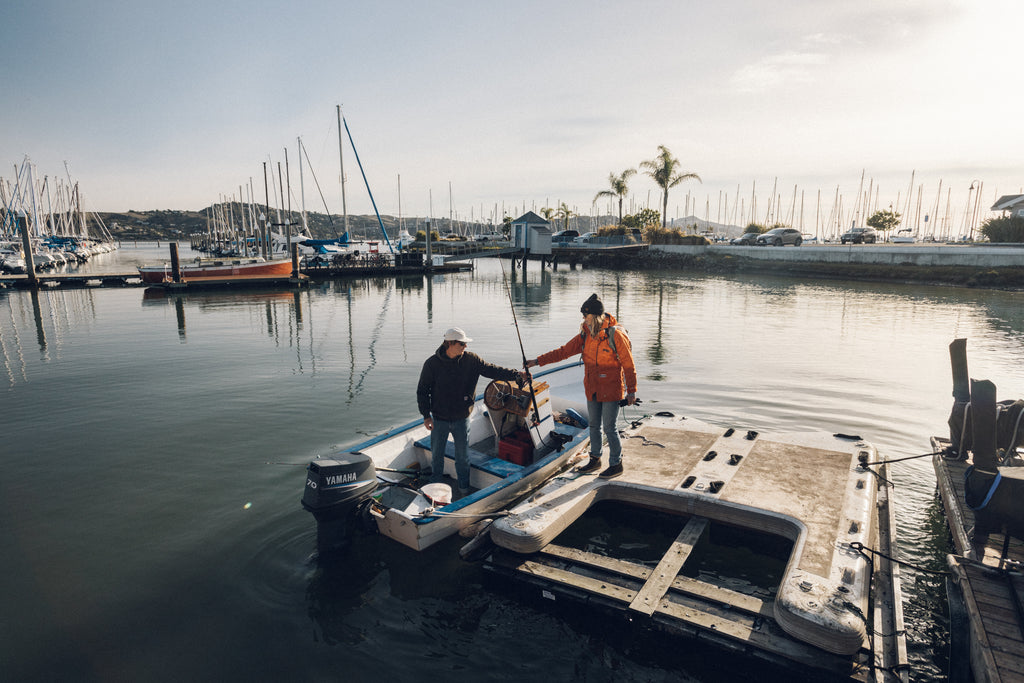 Two people loading a boat at the dock to go out fishing