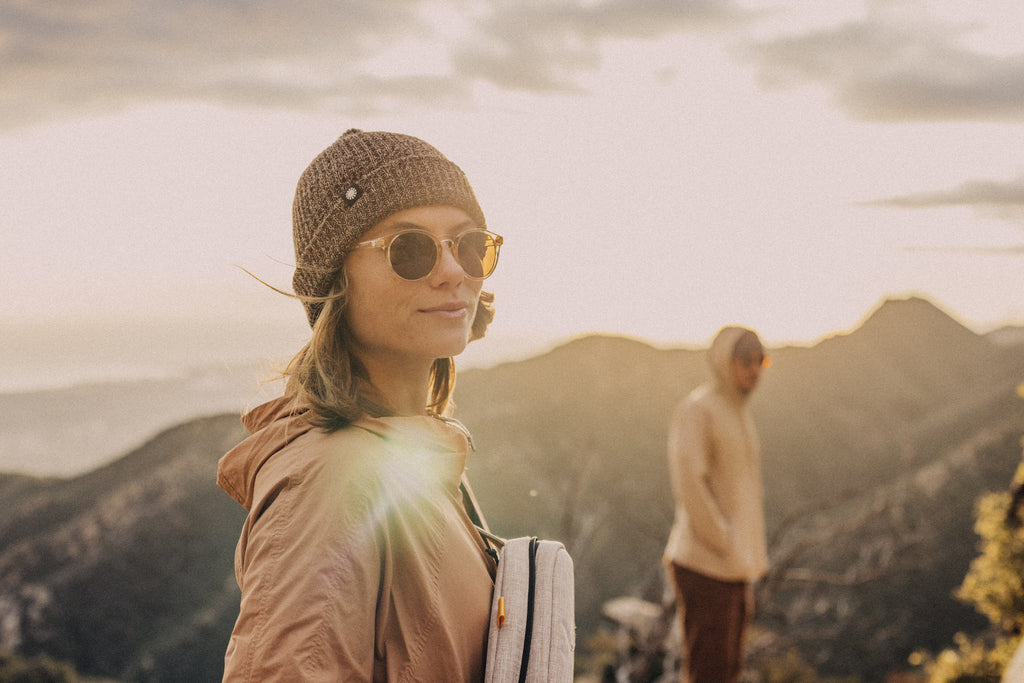 woman wearing sunski sunglasses, beanie and sling