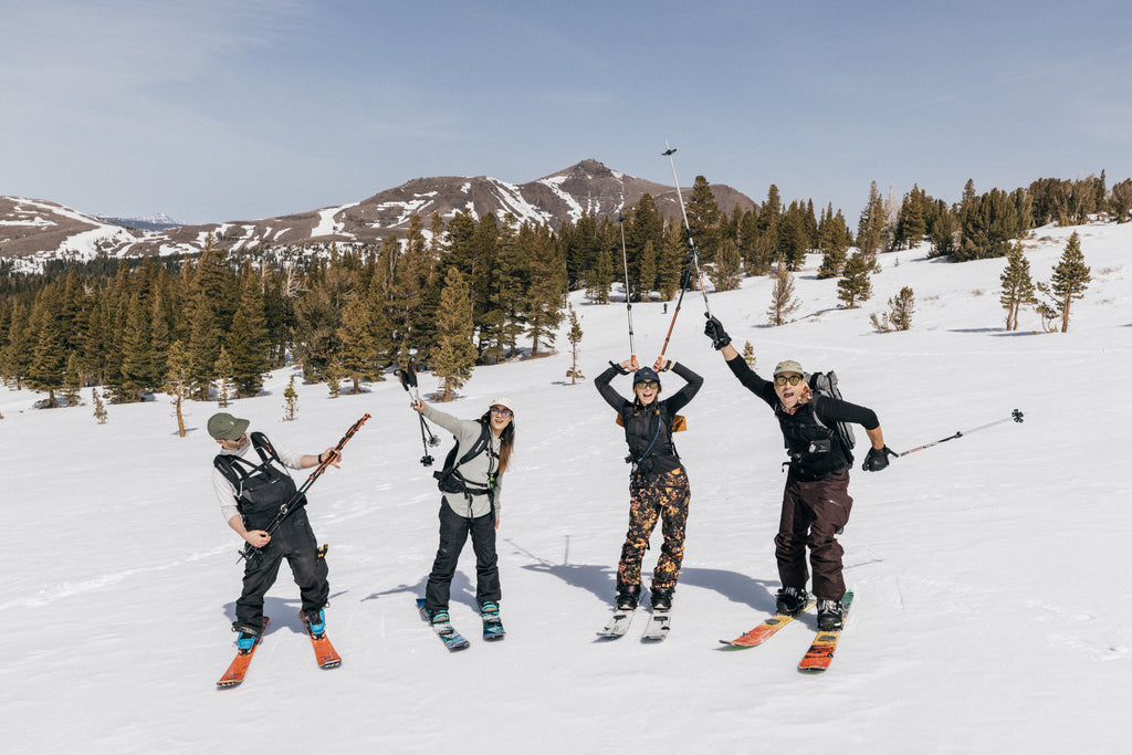 Four skiers striking a pose on a sunny slope