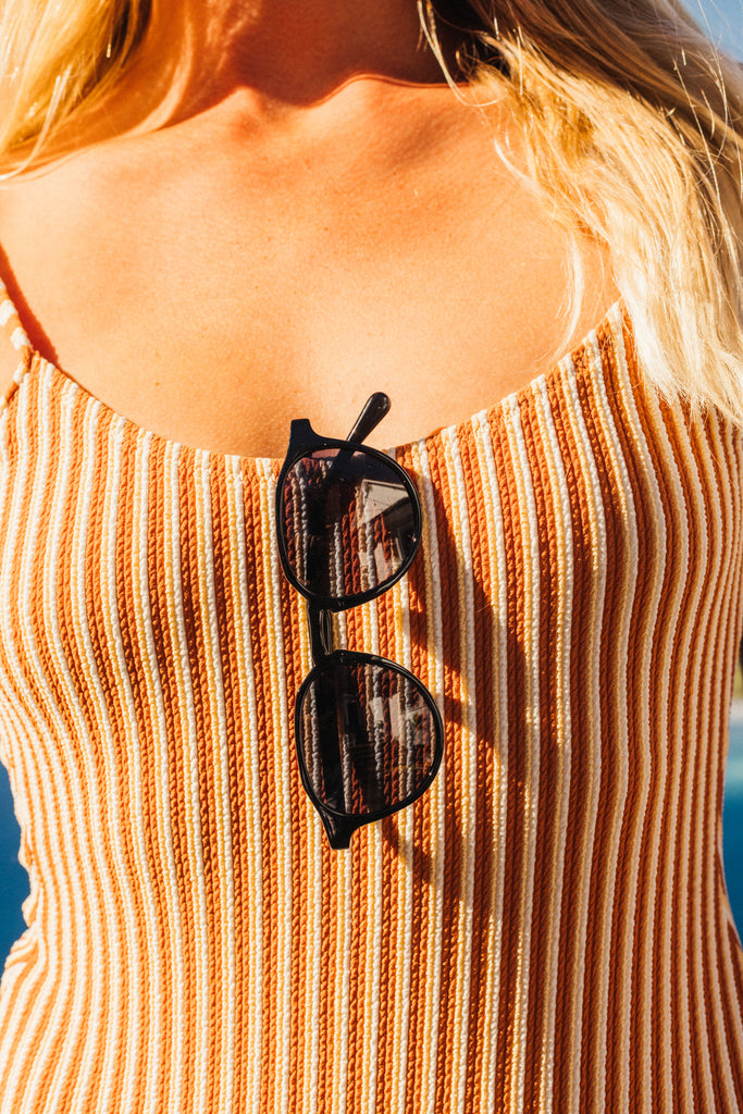 sunski vallarta sunglasses hanging on a bathingsuit
