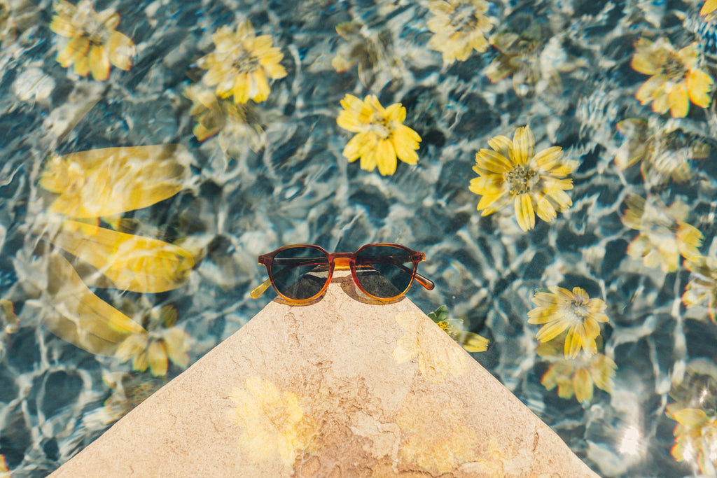 sunglasses on the corner of a pool