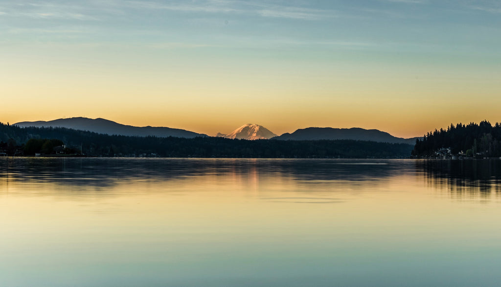 Lake view of the sunny glow behind the mountains