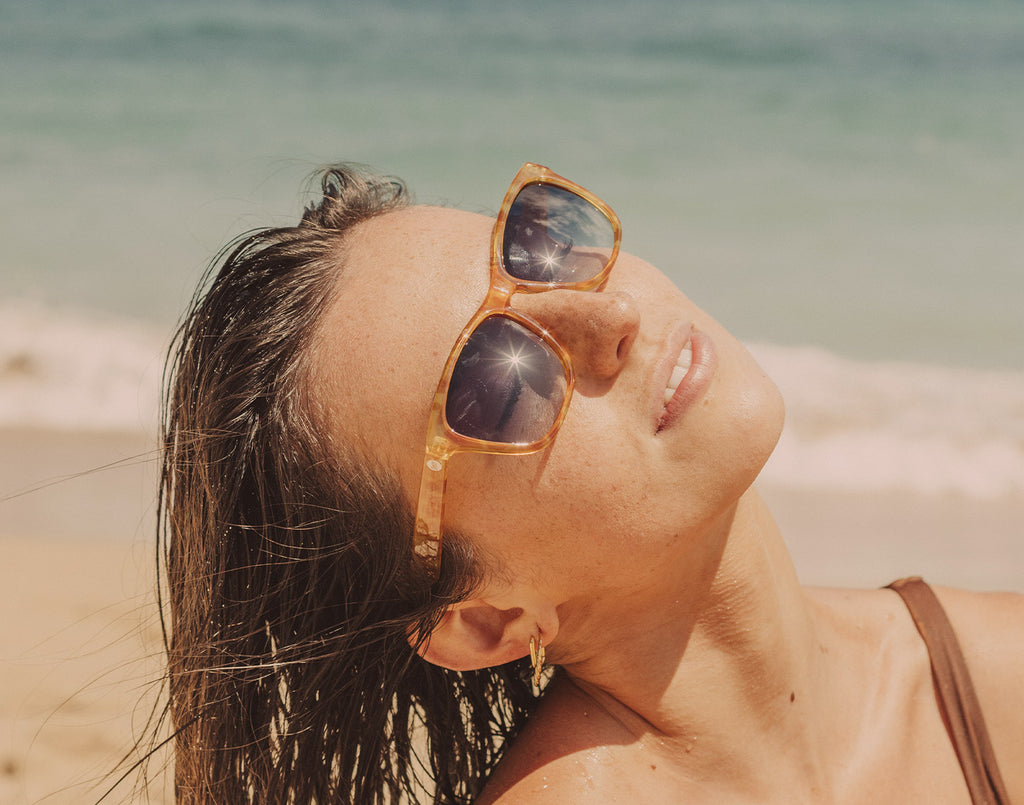 Girl wearing polarized sunglasses while looking up at the sky