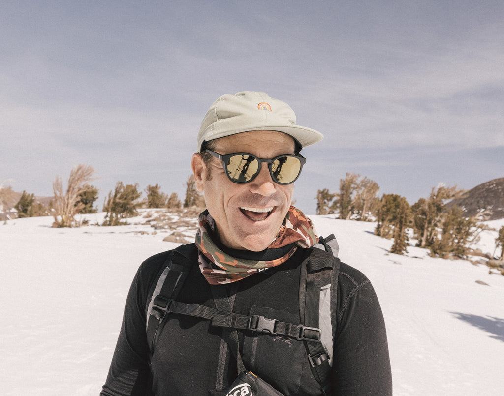 Man smiling while wearing a pair of polarized sunglasses in the snow