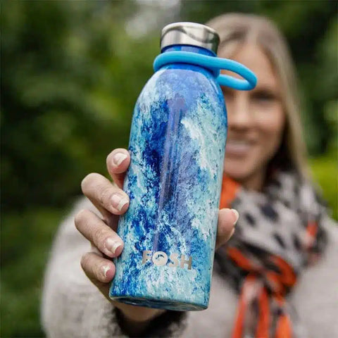 woman holding reusable, eco friendly water bottle