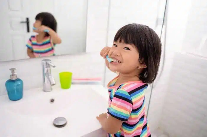 kid brushing teeth wondering what does fluoride do in toothpaste