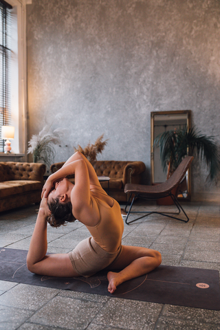 chica rajakapotasana en casa