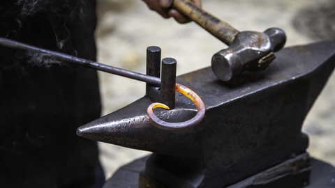 A Picture Displaying a Forger Bending the Steel to Form a Viking Arm Ring Upon an Anvil