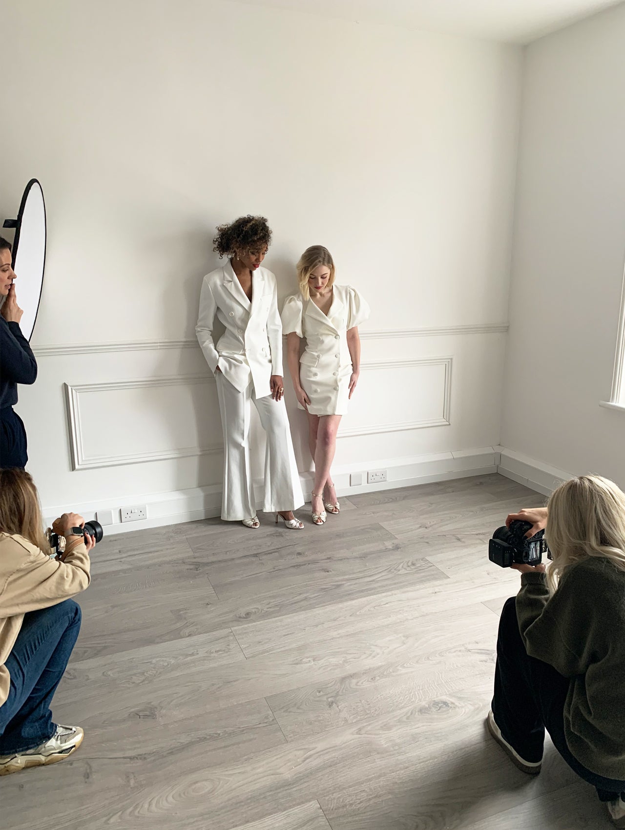 Two models in modern bridal wear being photographed in a studio