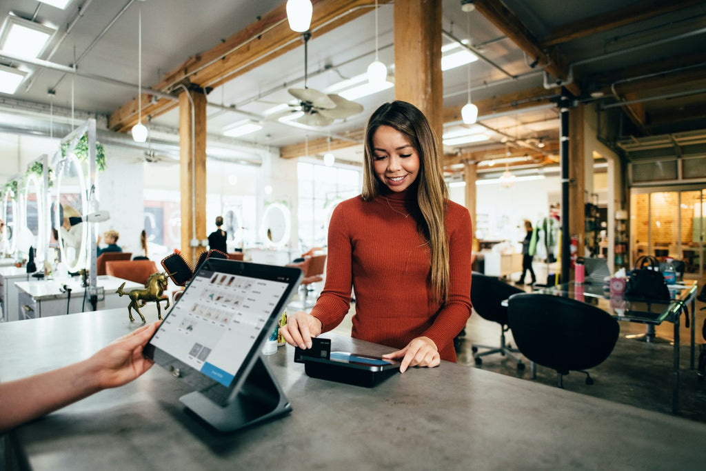 Lady paying at the till. Photo by Blake Wisz on Unsplash 