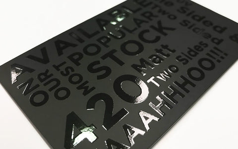 "A sleek black and white business card with a glossy spot UV coating highlighting the logo and contact information. The thick cardstock and high-quality printing give the card a professional and premium feel."