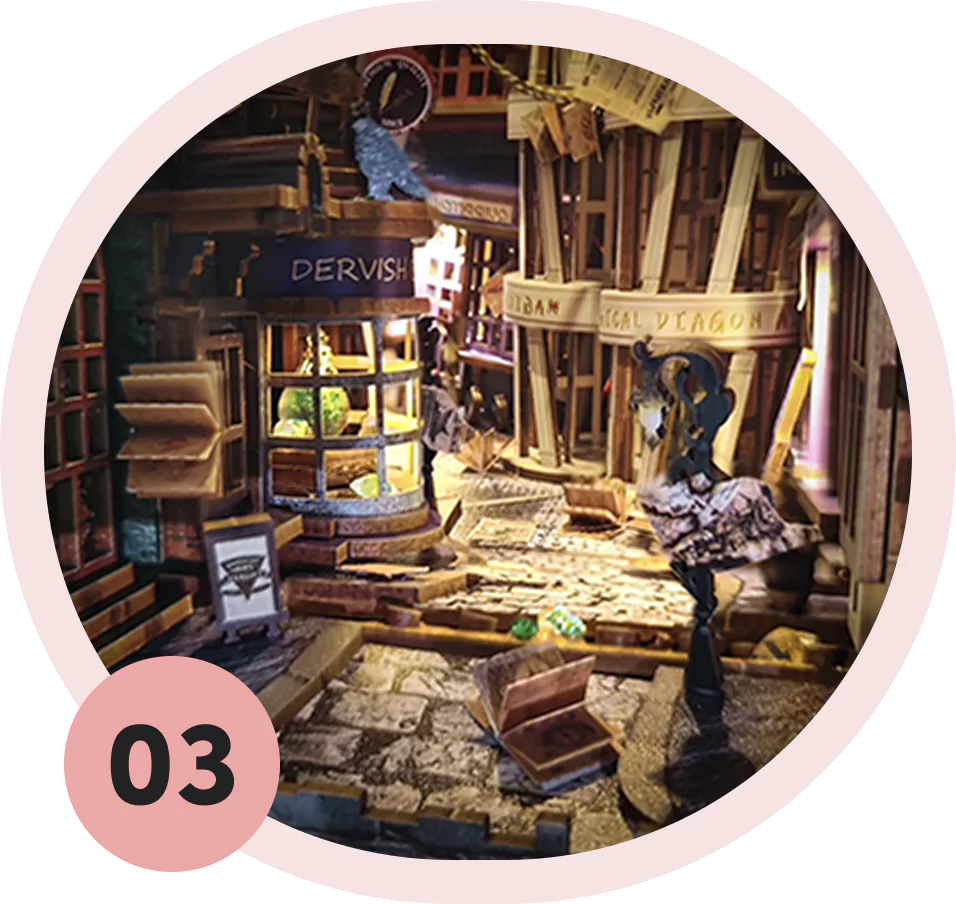 A detailed diorama of a magical street with shops and cobblestone path.