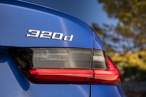 BMW 320d tail light, showing its distinctive design with sleek, modern elements and clear lens. The image highlights the tail light's stylish appearance and its prominent '320d' badge.