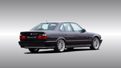 BMW M5 E34 displayed, featuring the bold, angular design of the early 1990s with its signature quad headlights, wider stance, and refined performance look, representing the second generation M5 known for its increased power and more muscular presence.