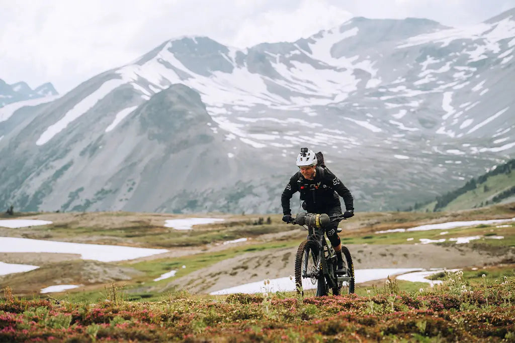 Un ciclista in mountain bike con abbigliamento mtb invernale Fox