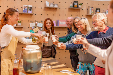 Group of kombucha brewing students "cheersing to their own gut health mastery" with proud founder, and teacher, Hebe - boochacha